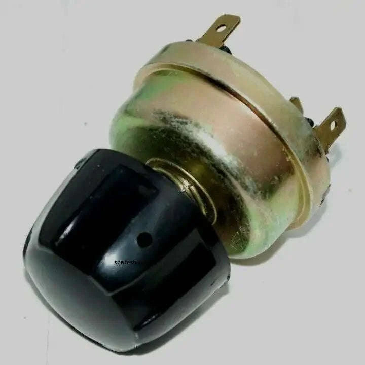 Automotive light switch with black plastic housing and gold metal mounting tabs