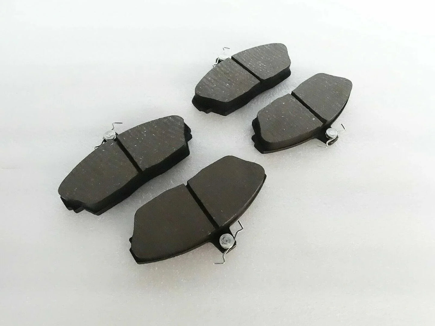 Brake disc pad set with dark friction pads and metal spring clips