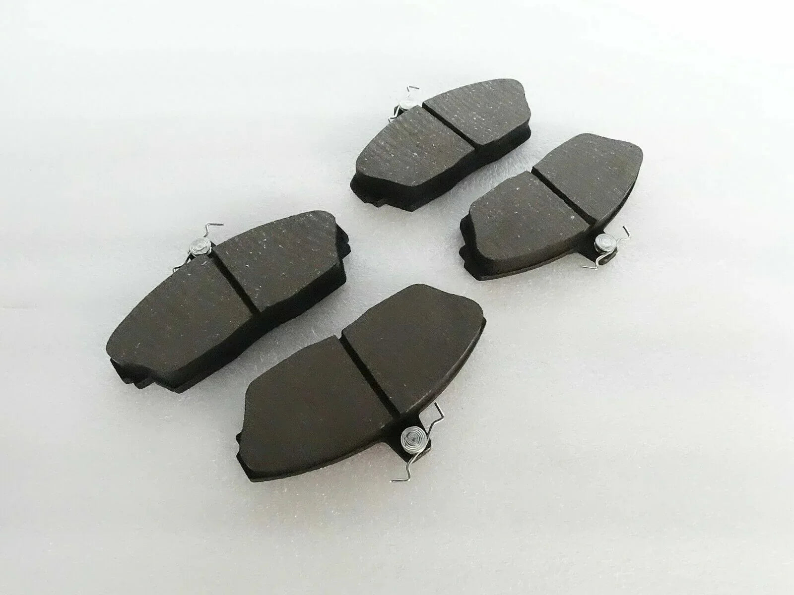 Brake disc pad set with dark friction pads and metal spring clips
