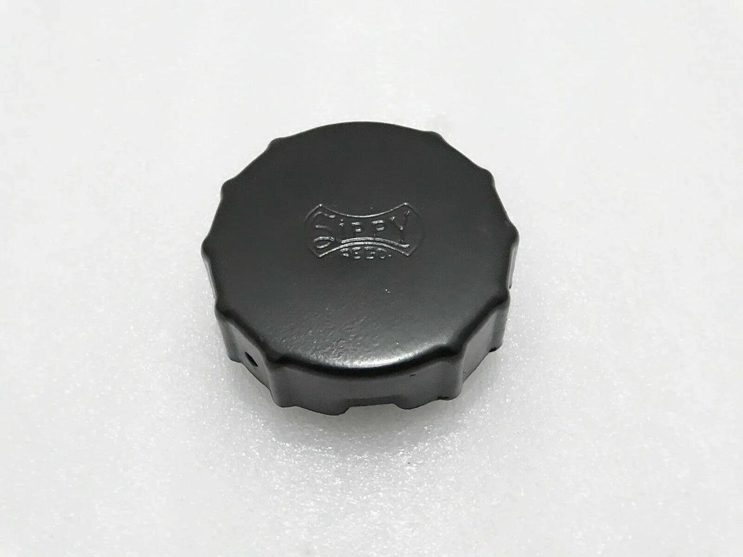 Black tractor fuel tank cap with embossed emblem, octagonal top