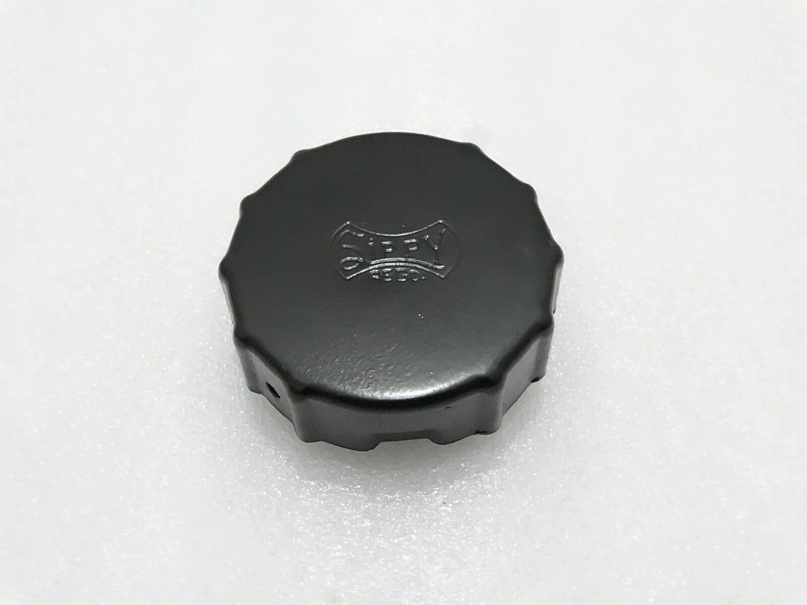Black tractor fuel tank cap with embossed emblem, octagonal top