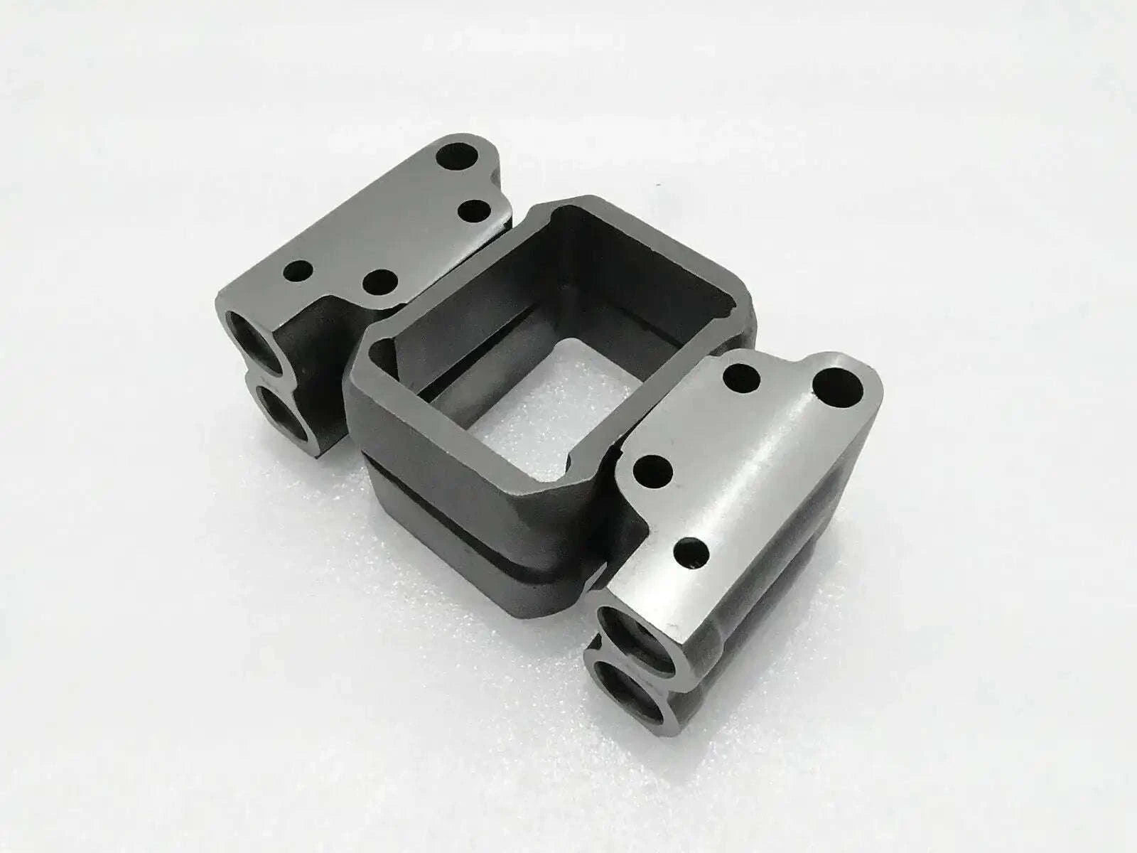 Hydraulic pump valve block with mounting flanges, metal and black finish.