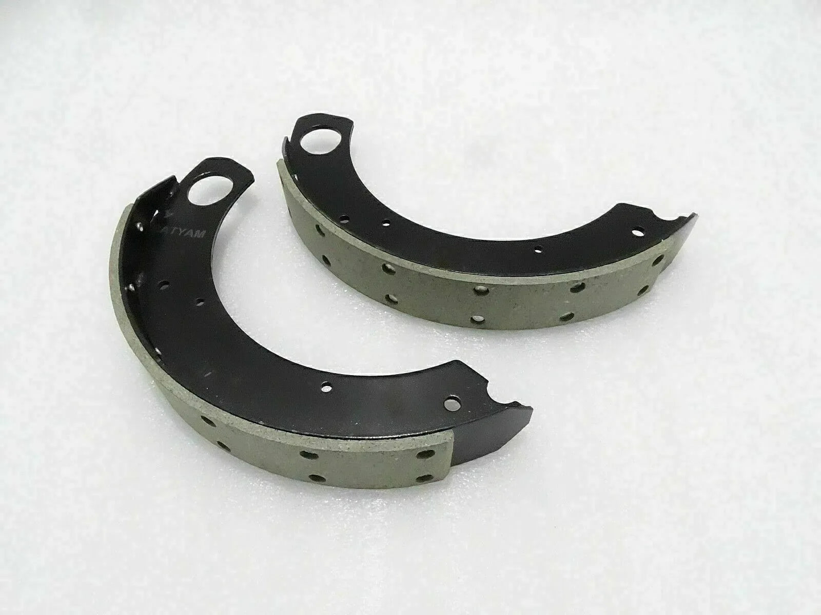Curved tractor brake shoe lining set with black metal backing and rivet holes