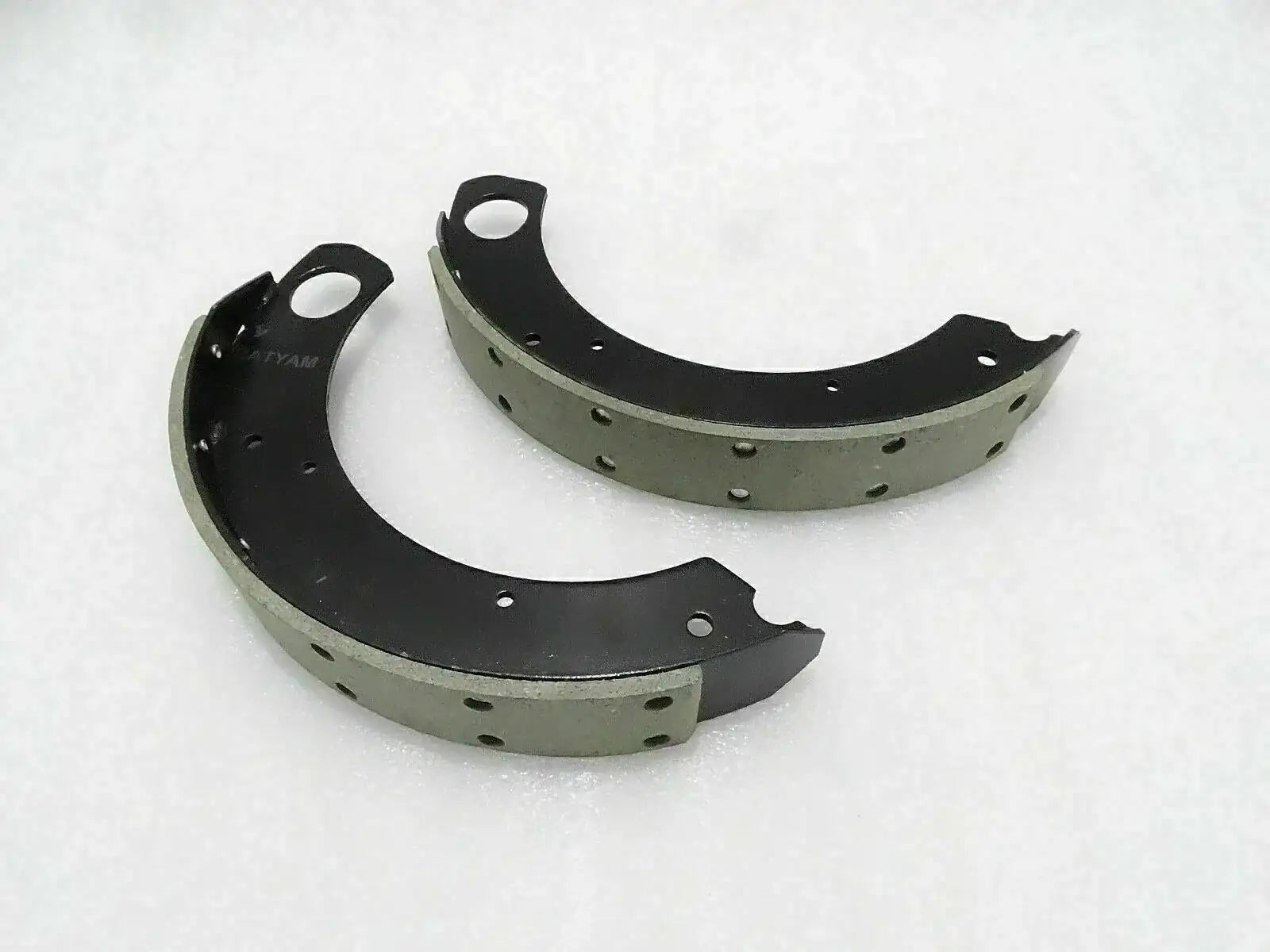 Curved tractor brake shoe lining set with black metal backing and rivet holes