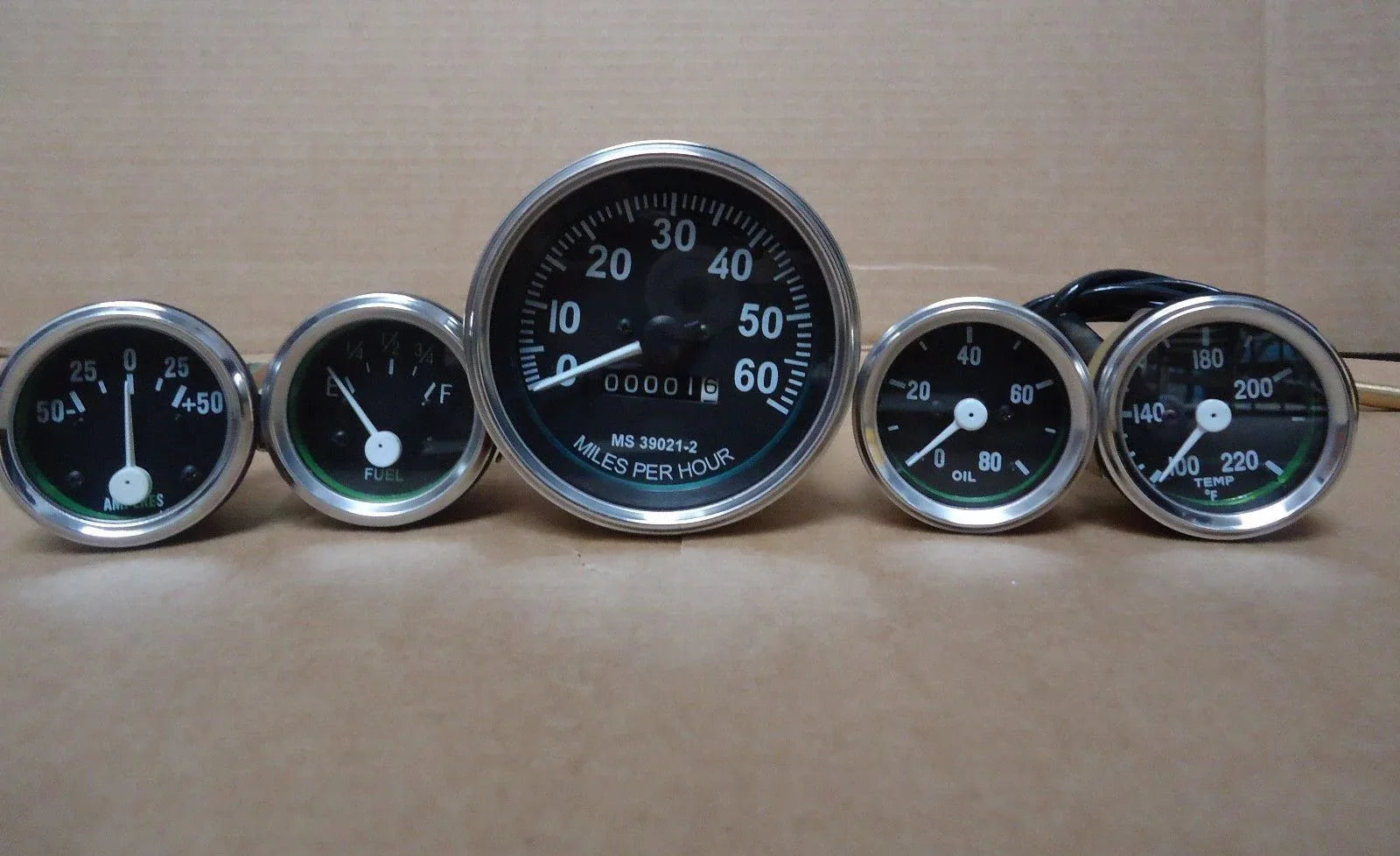 Analog vehicle gauges kit with chrome bezels, five round dials and black faces
