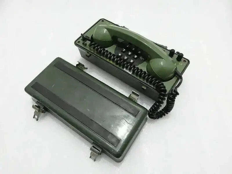 Military green field telephone with handset and keypad, angled view