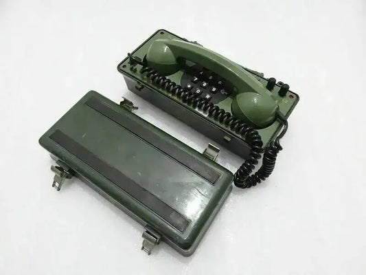 Military green field telephone with handset and keypad, angled view