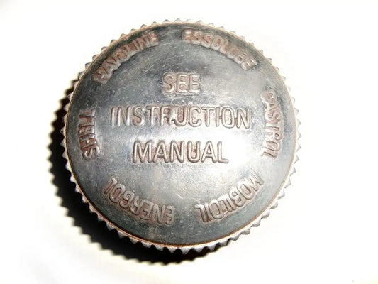 Metal oil tank filler cap with embossed text and serrated edge