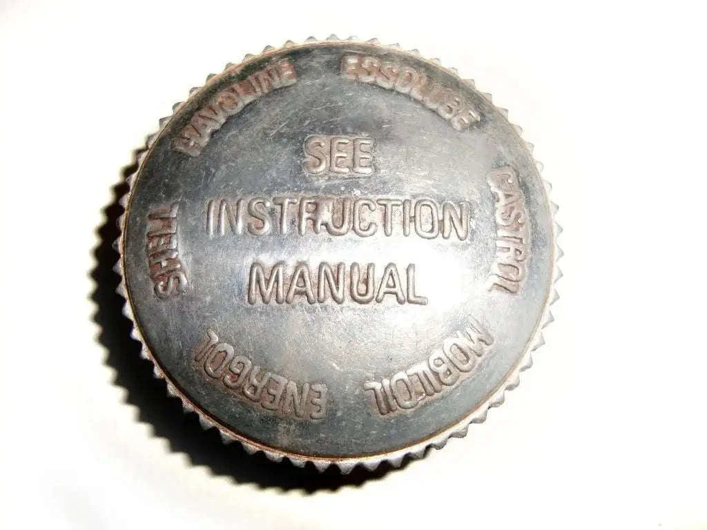Metal oil tank filler cap with embossed text and serrated edge