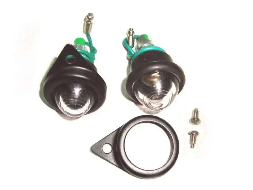 Pair of pilot lamp assemblies with black rims, bulbs, mounting bracket and screws
