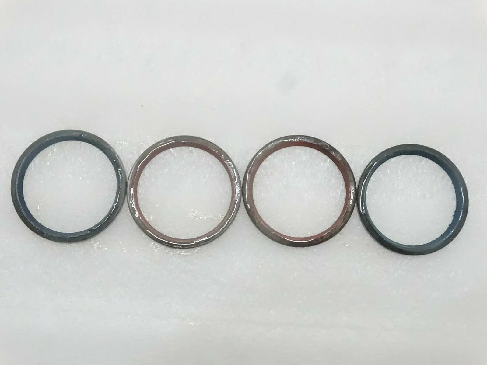 Set of 4 rubber seal rings with metal outer edges, dark and brown