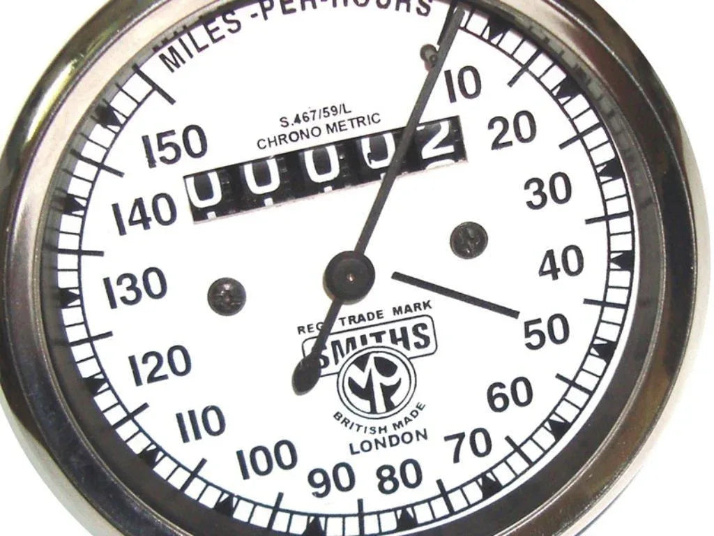 Vintage speedometer dial with white face, 0–150 mph scale.