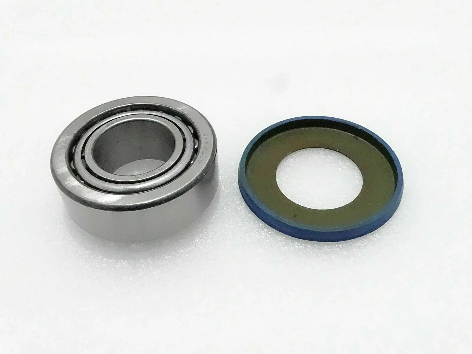 Steering knuckle trunnion bearing with seal ring, metal ball bearing and rubber seal
