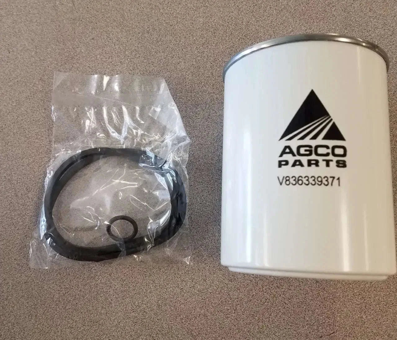 Fuel filter canister with O-ring seals, silver top, black ring, AGCO Parts label