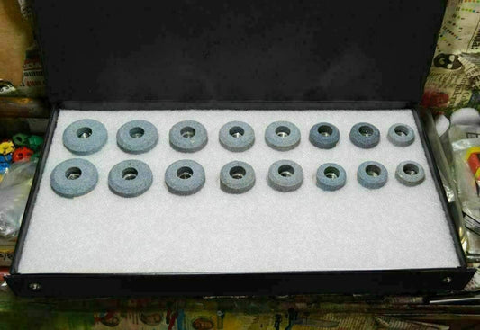 Valve seat grinding stones set in a black storage case with various sizes