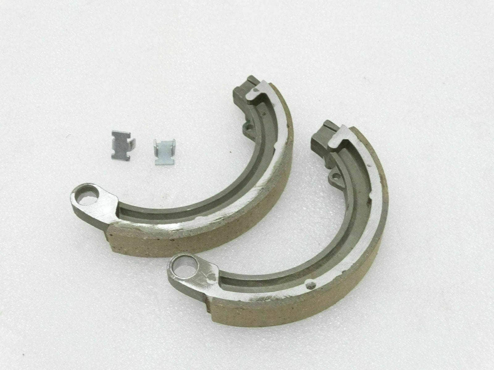Front brake shoe kit with two curved brake shoes and metal clips