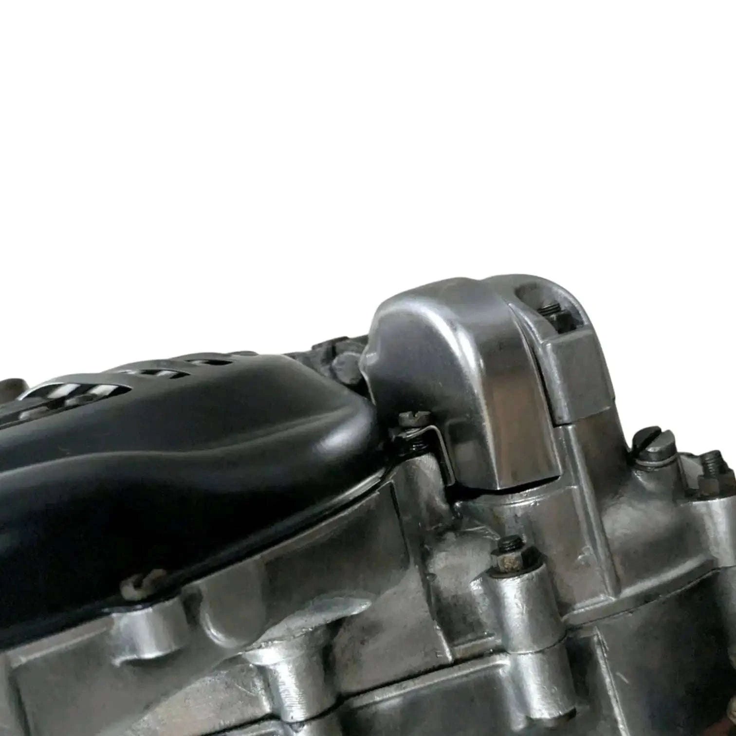 Engine assembly close-up of silver cylinder head and black cover