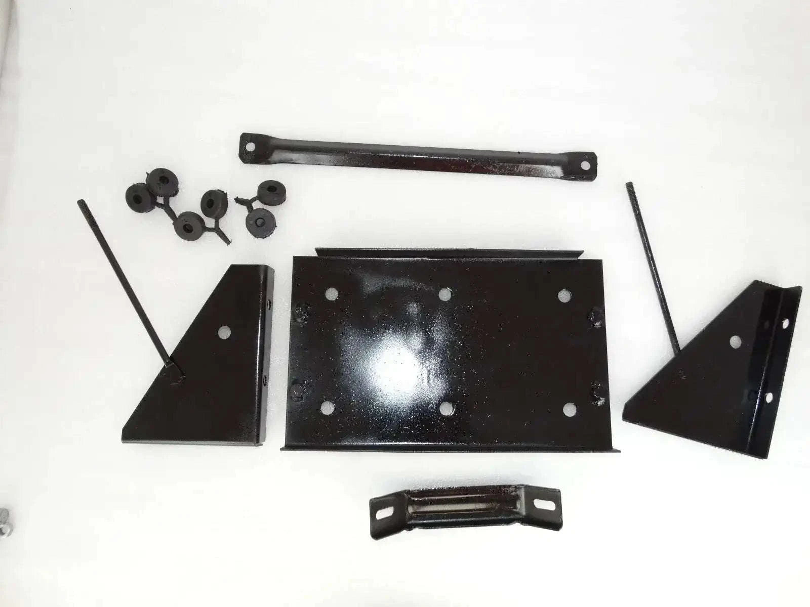 Vintage battery stand assembly parts: black metal brackets, plates, and hardware pieces