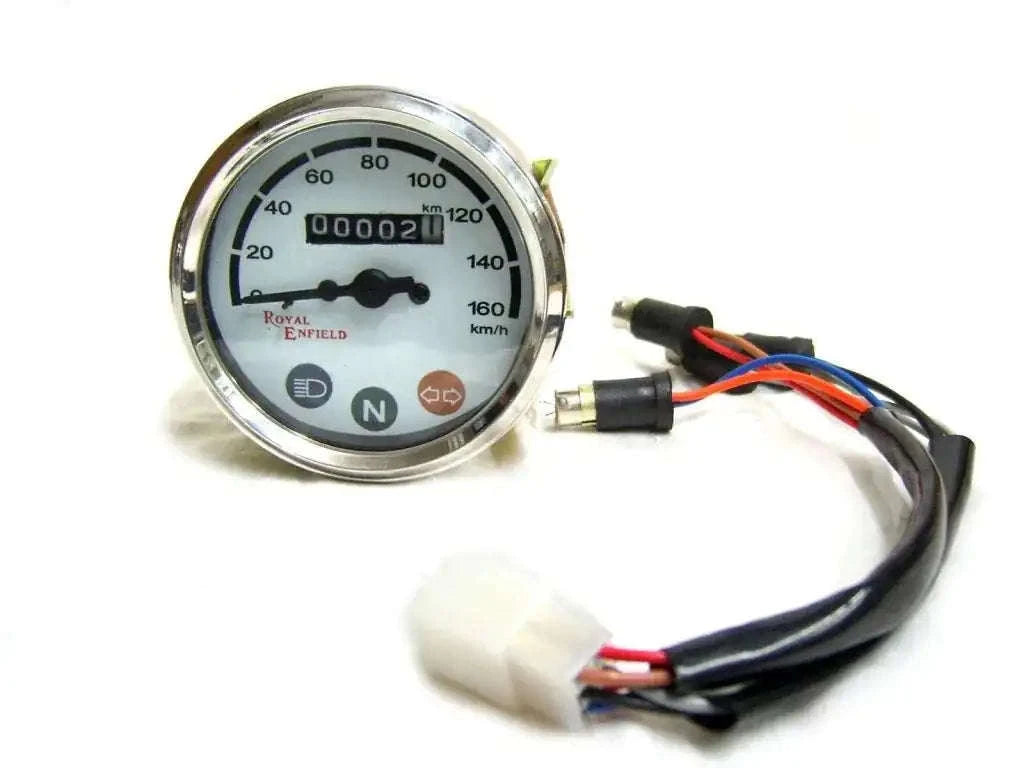 Vintage motorcycle speedometer gauge with white face, chrome bezel, and wiring harness