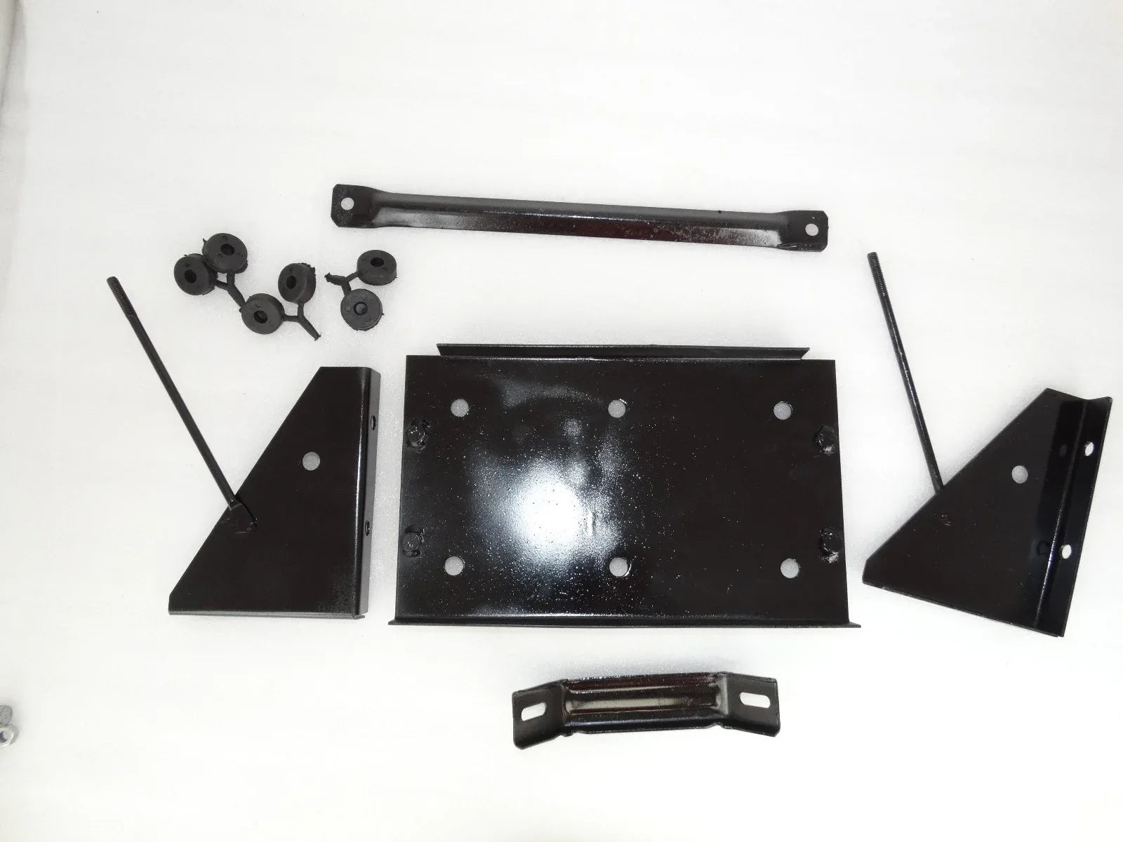 Vintage battery stand assembly parts: black metal brackets, plates, and hardware pieces