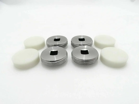 Set of 4 wear pads with white bases and silver metal caps.